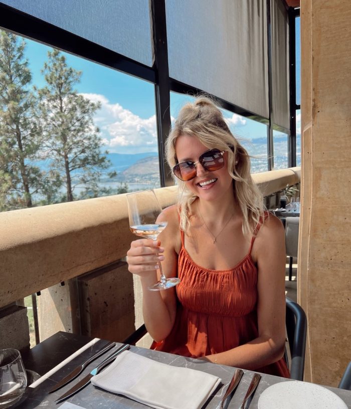 Blonde girl smiling with wine on patio
